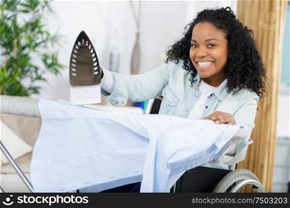 happy woman or housewife with ironing board at home