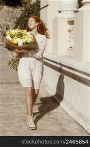 happy woman outdoors with bouquet spring flowers