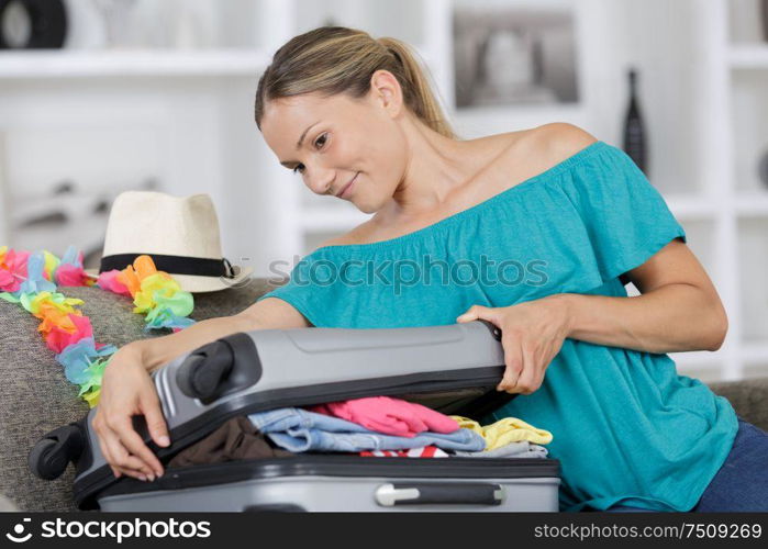 happy woman packing for holiday