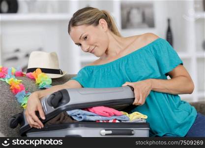 happy woman packing for holiday