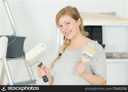 happy woman paints the walls