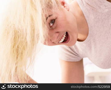 Happy woman playing with blonde hair. Positive clean female after taking a shower feeling clean and relaxed. Unusual crazy bottom angle.. Woman playing with blonde hair