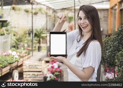 happy woman pointing digital tablet with blank white screen