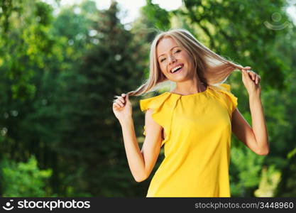 happy woman posing against a background of trees