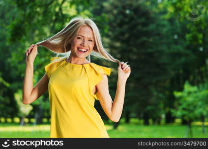 happy woman posing against a background of trees