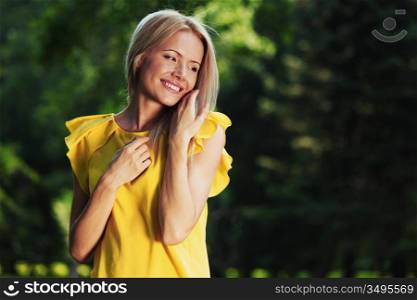 happy woman posing against a background of trees