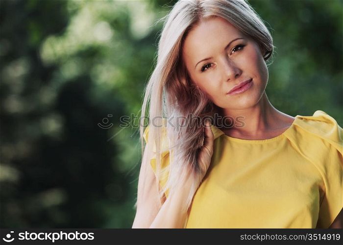 happy woman posing against a background of trees