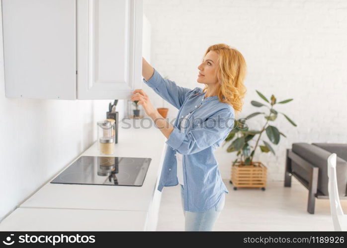 Happy woman prepares to cook fresh breakfast on the kitchen. Female person at home in the morning, healthy nutrition. Woman prepares to cook breakfast on the kitchen