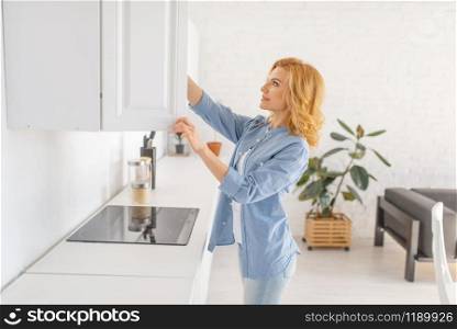 Happy woman prepares to cook fresh breakfast on the kitchen. Female person at home in the morning, healthy nutrition. Woman prepares to cook breakfast on the kitchen