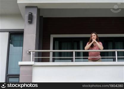 happy woman relaxing and looking from balcony of her home