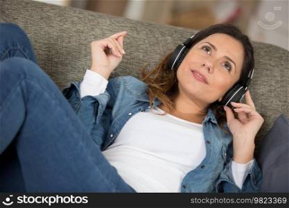 happy woman relaxing with music on her sofa