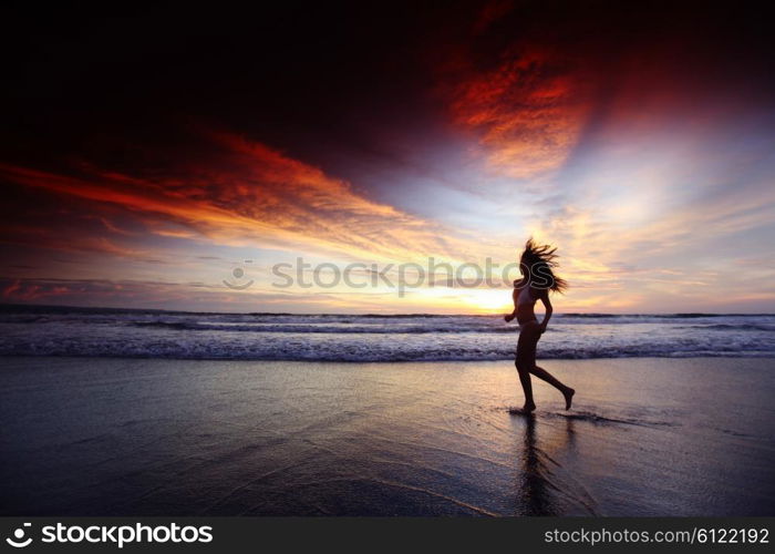 Happy woman running on the beach at sunset, Bali, Seminyak, Double six beach