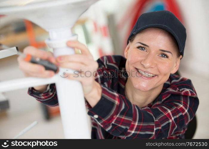 happy woman screwing a metal chair