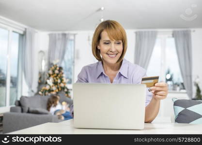 Happy woman shopping online at home during Christmas