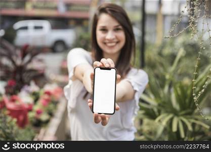 happy woman showing cellphone with blank white screen