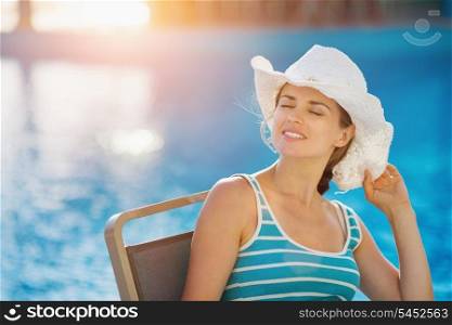 Happy woman sitting at pool bar