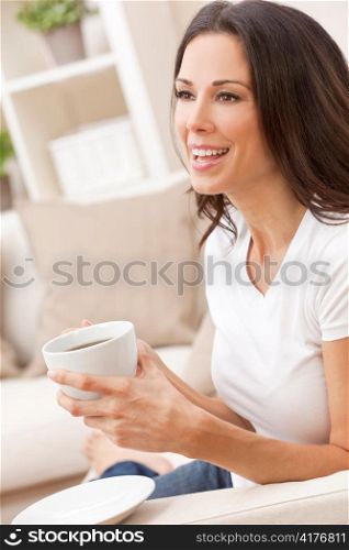 Happy Woman Sitting on Sofa Drinking Tea or Coffee