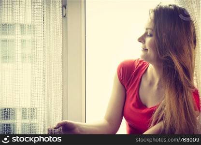 Happy woman sitting on windowsill, energizing morning thinking about day, relaxing having good time.. Happy woman sitting on windowsill, energizing morning