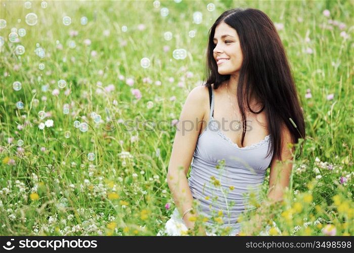 happy woman smile in green grass soap bubbles around