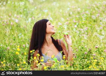 happy woman smile in green grass soap bubbles around