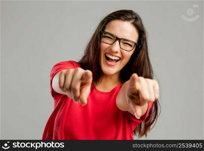 Happy woman smiling and pointing to the camera with both arms