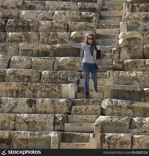 Happy woman standing on stone steps at Roman amphitheater, Bet She&rsquo;an National Park, Haifa District, Israel