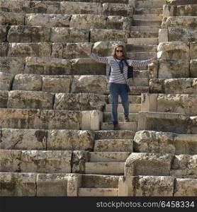 Happy woman standing on stone steps at Roman amphitheater, Bet She&rsquo;an National Park, Haifa District, Israel