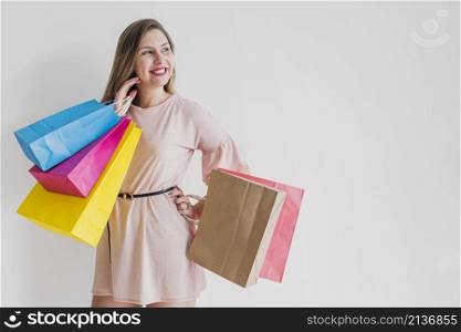 happy woman standing with bright shopping bags