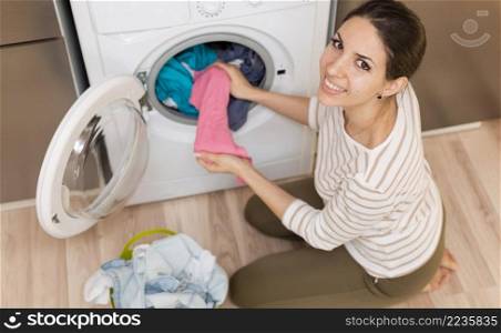 happy woman taking clothes out machine
