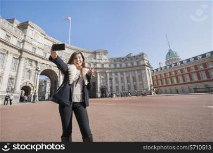 Happy woman taking self portrait against Admiralty Arch in London; England; UK