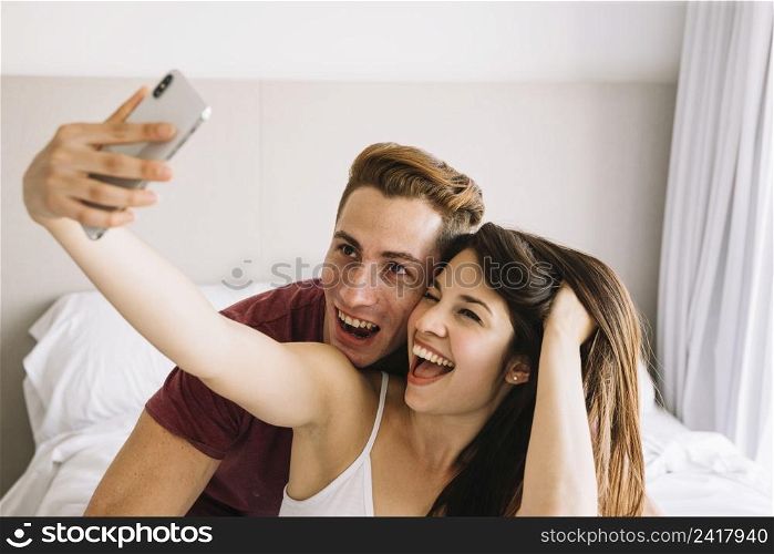 happy woman taking selfie with man