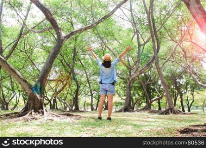Happy woman traveling in green forest