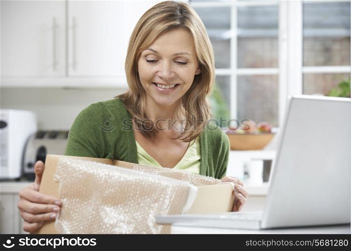 Happy Woman Unpacking Online Purchase At Home
