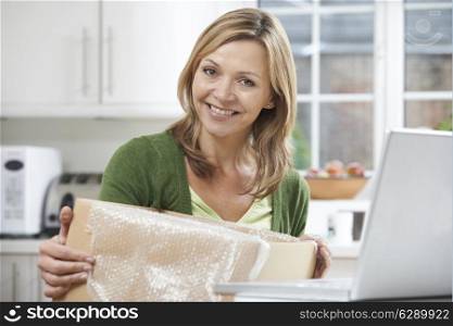 Happy Woman Unpacking Online Purchase At Home