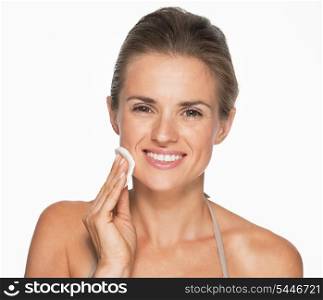 Happy woman using cotton pad to remove makeup