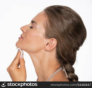 Happy woman using cotton pad to remove makeup