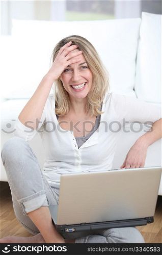Happy woman using laptop computer at home