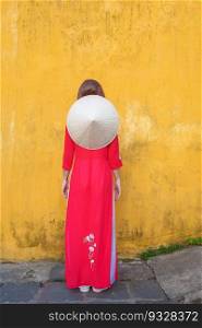 happy woman wearing Ao Dai Vietnamese dress and hat, trave≤r sightseeing at Hoi An ancient town in¢ral Vietnam. landmark and popular for tourist attractions. Vietnam and Southeast travel concept