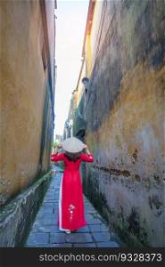 happy woman wearing Ao Dai Vietnamese dress and hat, traveler sightseeing at Hoi An ancient town in central Vietnam. landmark and popular for tourist attractions. Vietnam and Southeast travel concept