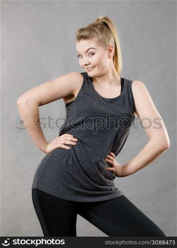 Happy woman wearing black tank top and leggings smiling having good mood. Sporty outfit. Happy woman wearing black tank top