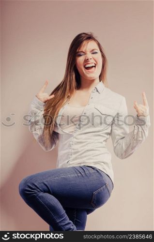Happy woman wearing denim pants. Girl celebrating success clenching fist filtered photo