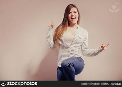 Happy woman wearing denim pants. Girl celebrating success clenching fist filtered photo