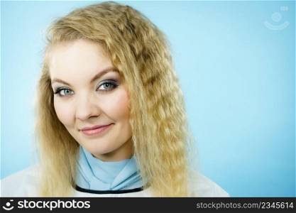 Happy woman wearing hairdressing collar having very dry hair with split ends. Blue background.. Woman wearing hairdressing collar