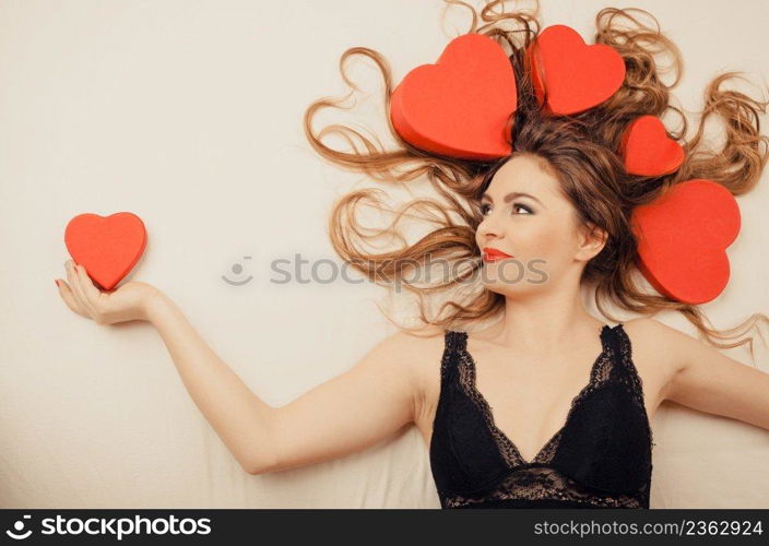 Happy woman wearing lingerie in bed at home. Attractive seductive young girl with heart shape boxes around head. Female underwear fashion. Valentines day love.. Woman in lingerie in bed. Valentines day love.