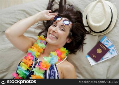 happy woman wearing sunglasses lying on the bed