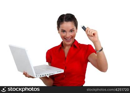 Happy woman with a USB key and laptop