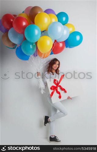 Happy woman with balloons. Happy woman with many colorful balloons and gift box