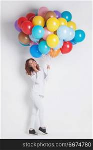 Happy woman with balloons. Happy woman with many colorful balloons on white