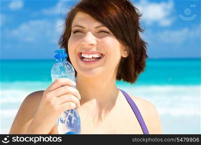 happy woman with bottle of water on the beach