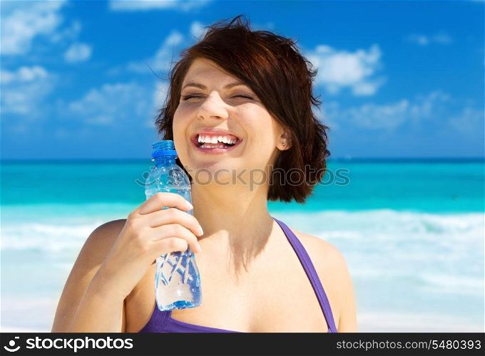 happy woman with bottle of water on the beach